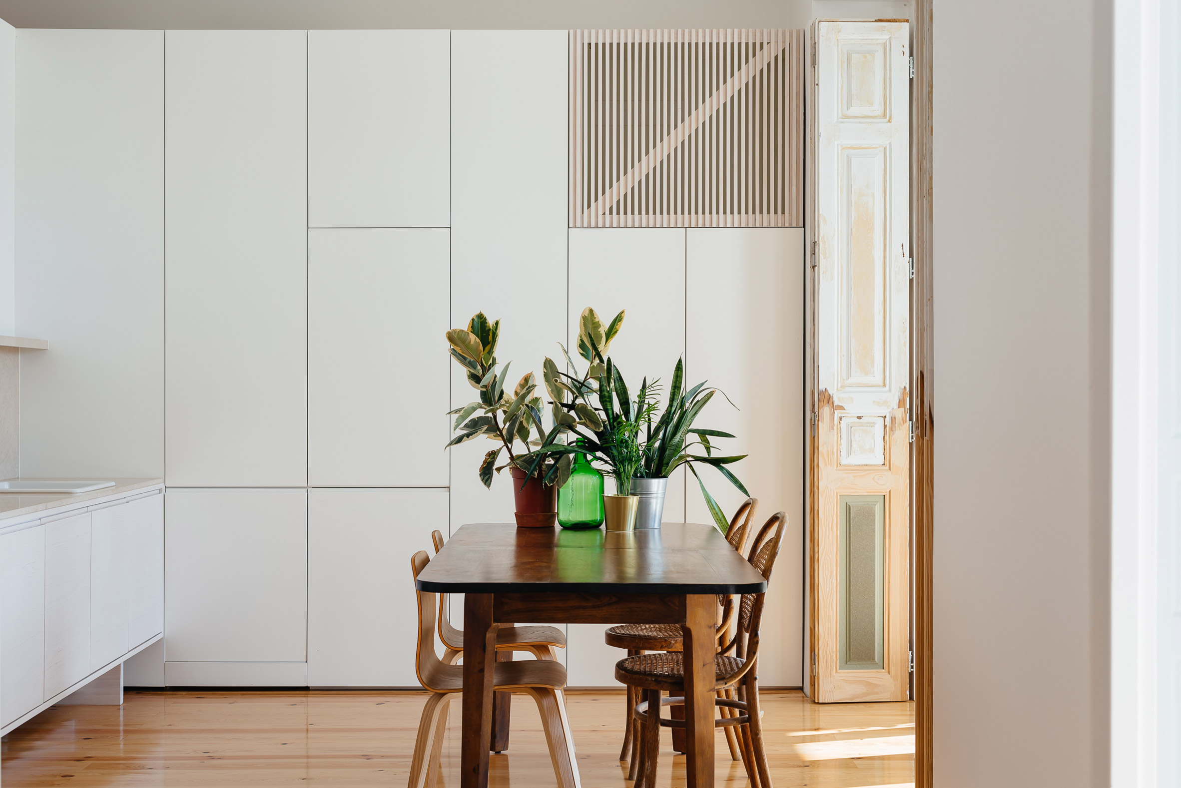 Mismatched chairs inside Apartment in Lapa's dining room by Filipe Fonseca Costa
